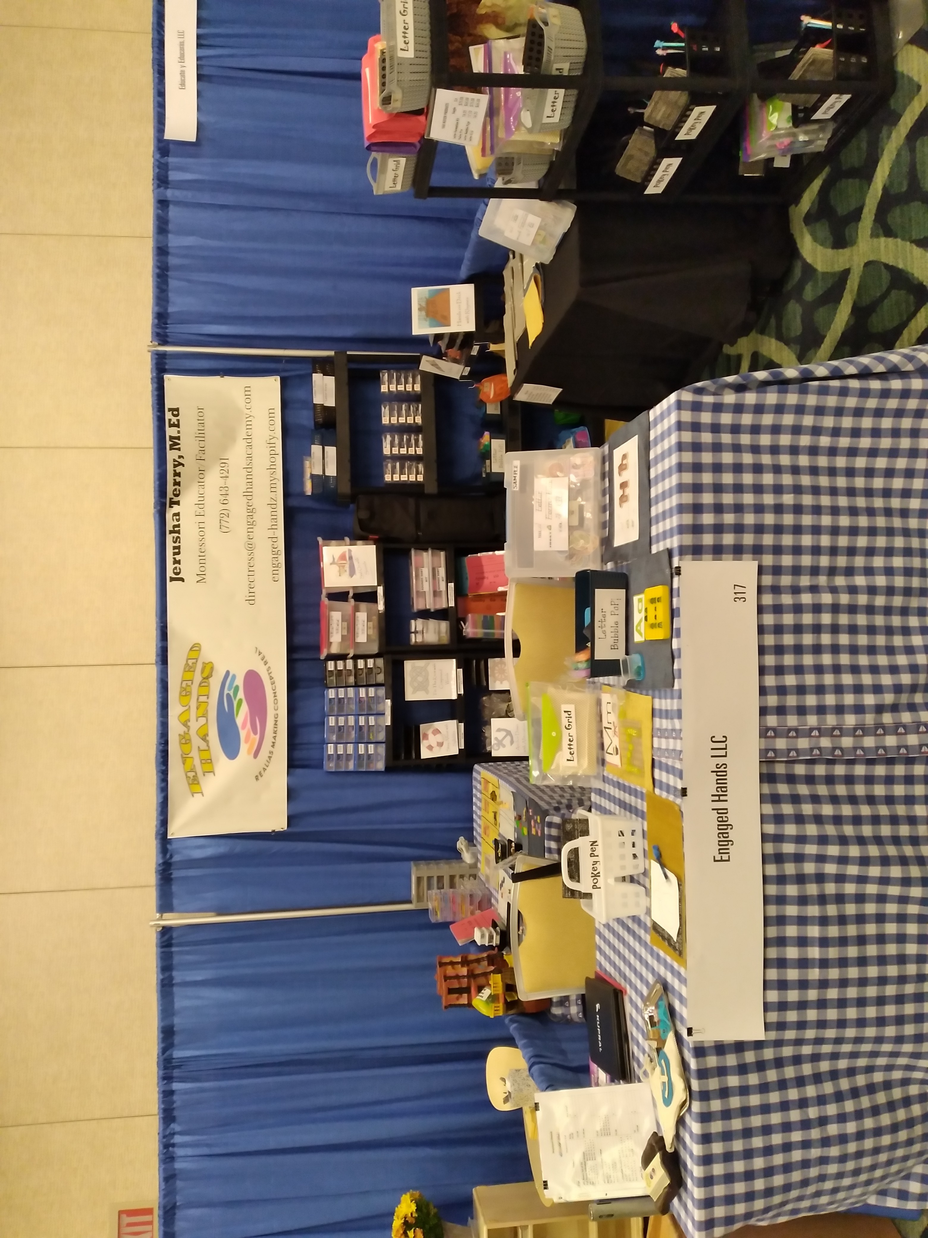 Engaged Hands learning materials booth display with baskets, cards, and hands-on educational tools